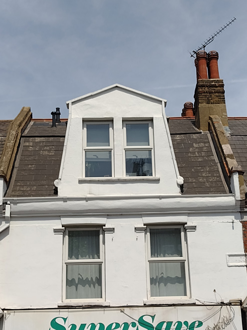 Figure 61: Detail of the dormer and pediment at no.250 Upper Richmond Road West. This is the least well preserved of the four as it has lost the pediment completely and the cornice below has been obscured. There are also unsympathetic replacement windows.