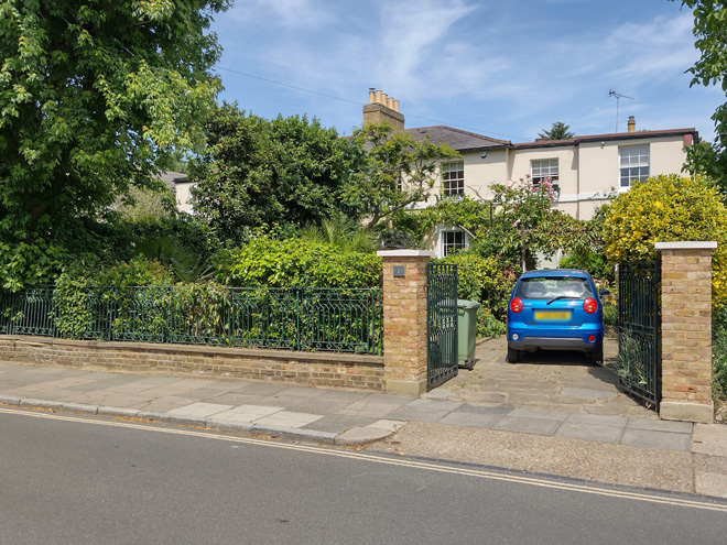 Figure 13: 2 Trafalgar Road, with decorative metal railings, a two-storey side extension, and a verdant garden which contributes to the suburban character of the area